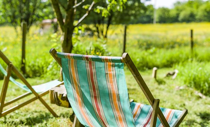 Deckchairs down by the river at  Erwain Escapes. Wonderful setting to relax with a book and a cuppa - Luxury Glamping Cabins with Hot Tubs - Brecon Be